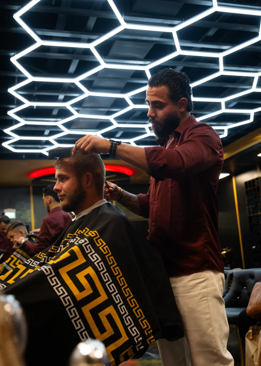Barber stylt einen Kunden am Spiegelplatz