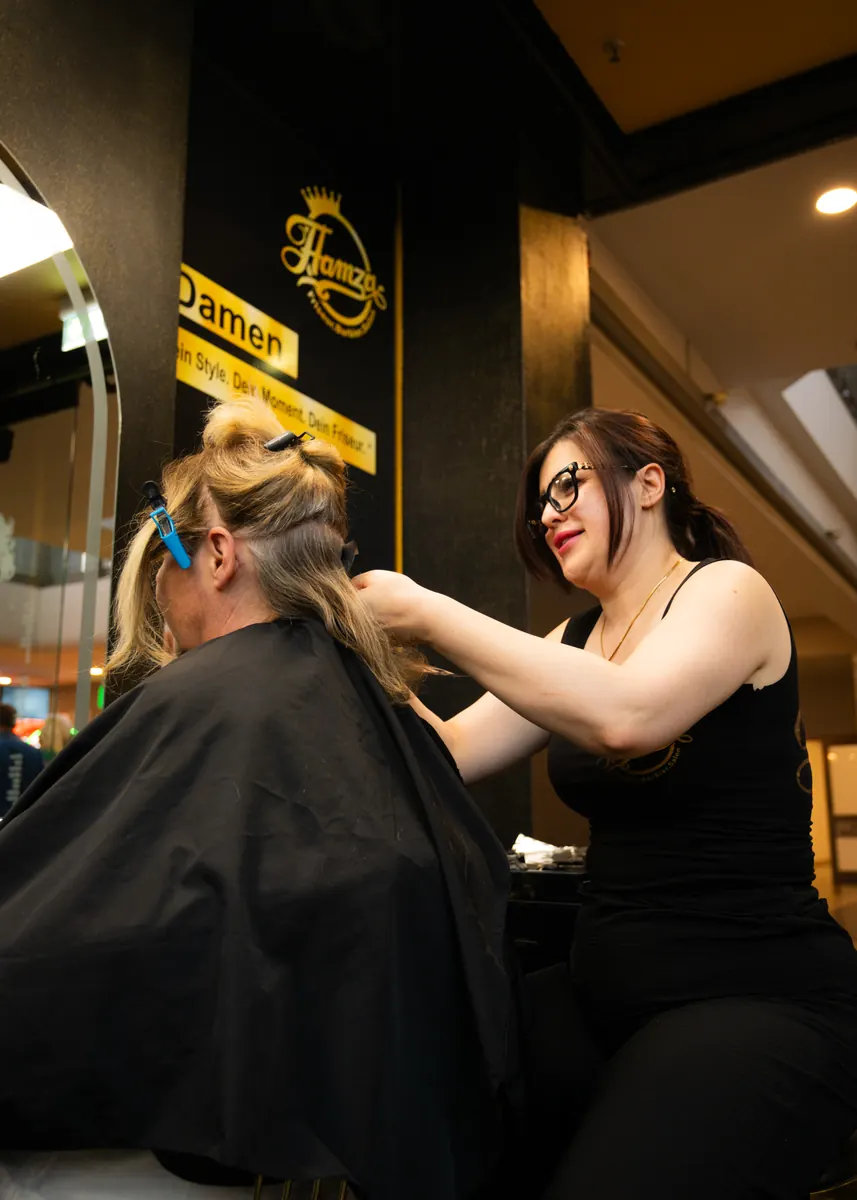 Friseurin schneidet einer Kundin die Haare