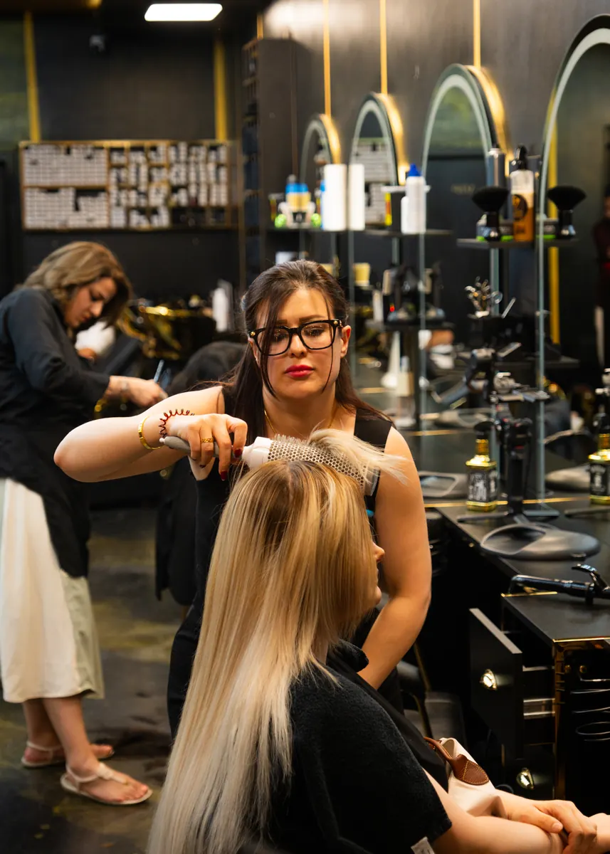 Damen-Styling: langes blondes Haar wird geschnitten