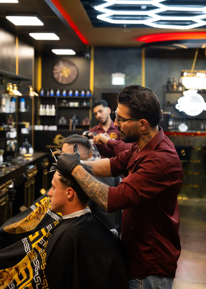 Blick in den Salon mit Barber bei der Arbeit